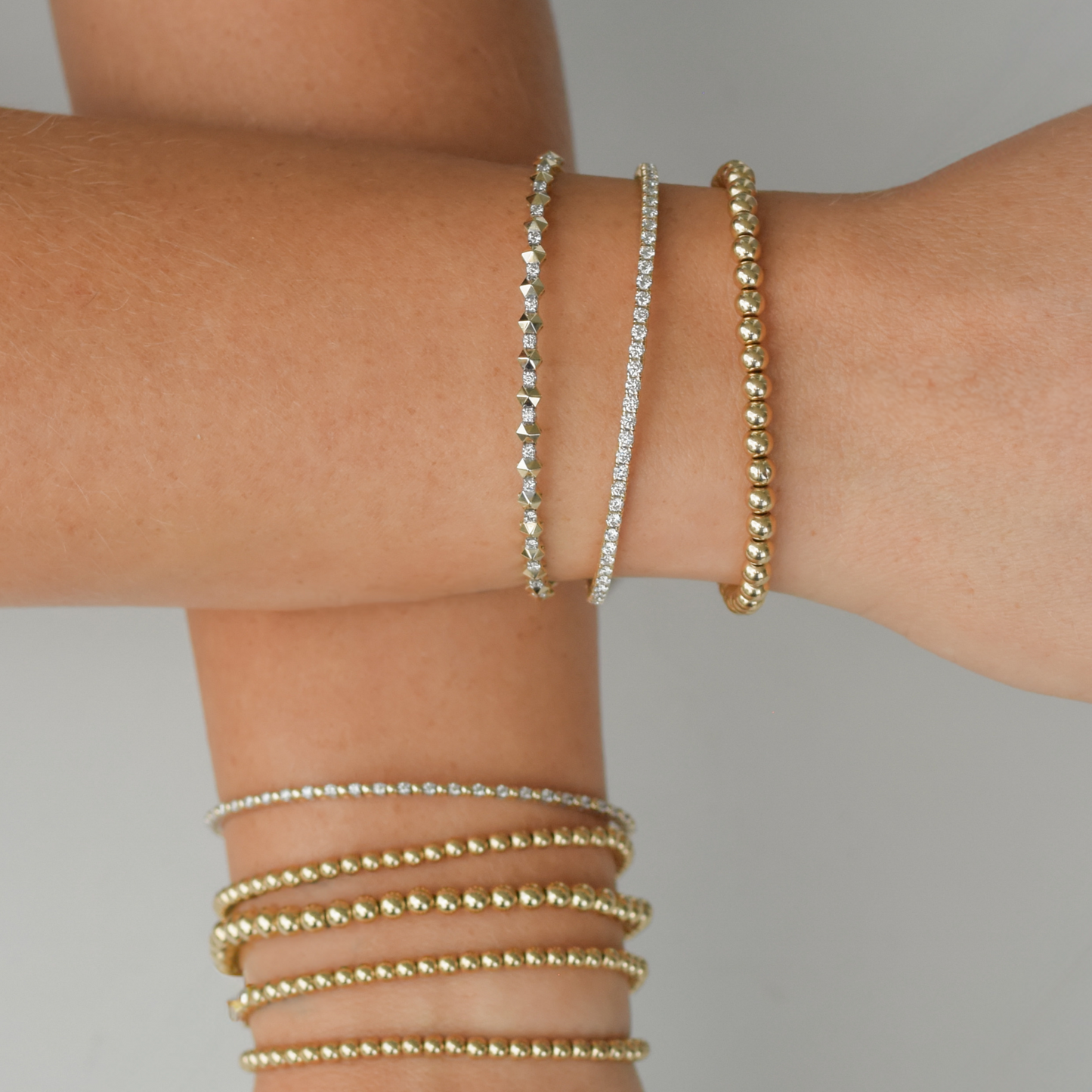 Stacked wrist style with Gold Club diamond flex bangles and 14k gold LustraFlex™ bead bracelets