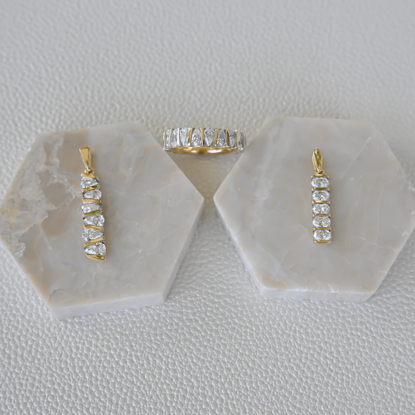 Display of Gold Club by Shannon Hudson fine jewelry featuring two lab-grown diamond bar pendants and a 14k gold diamond ring