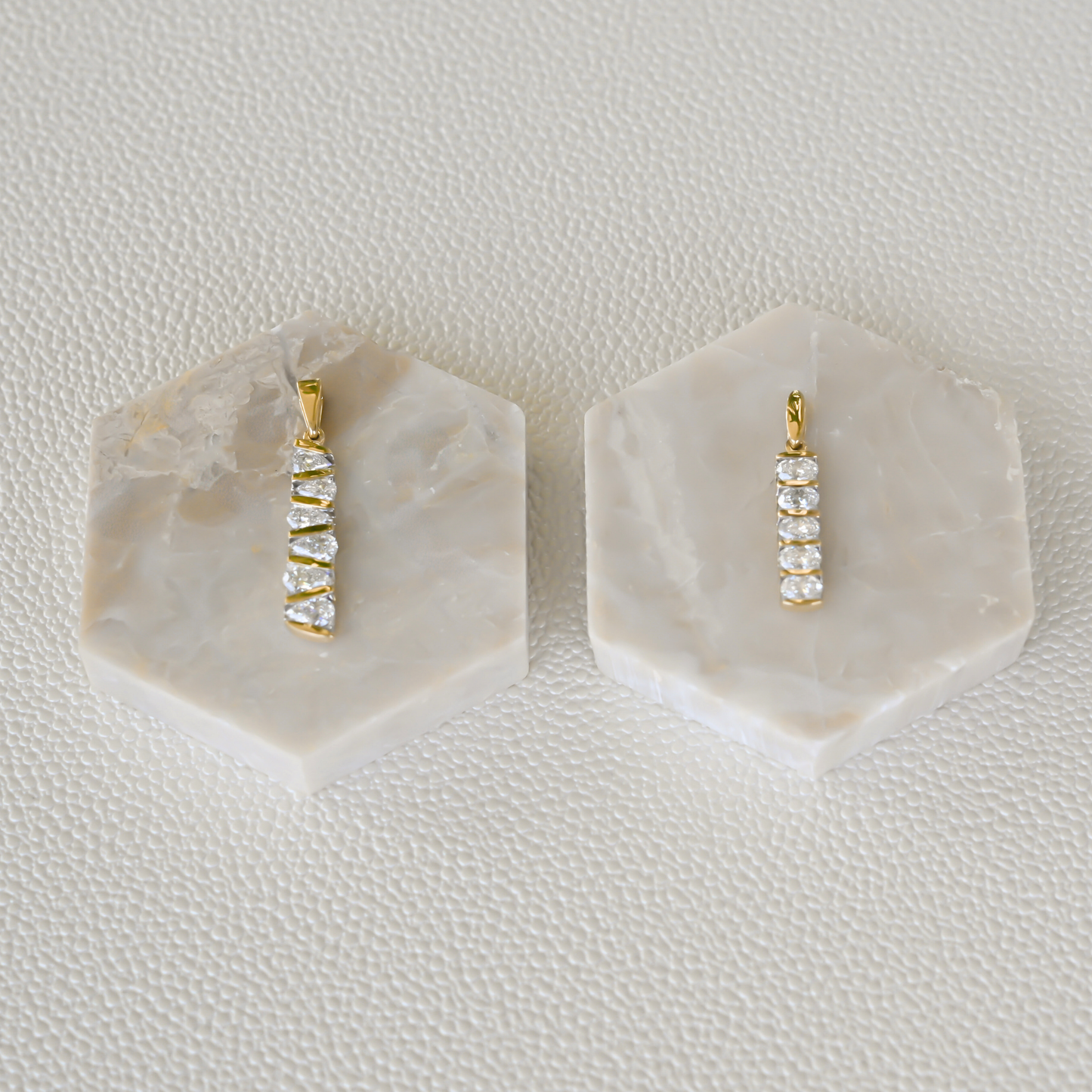 Two fine jewelry diamond bar pendants from Gold Club by Shannon Hudson on display in 14k gold