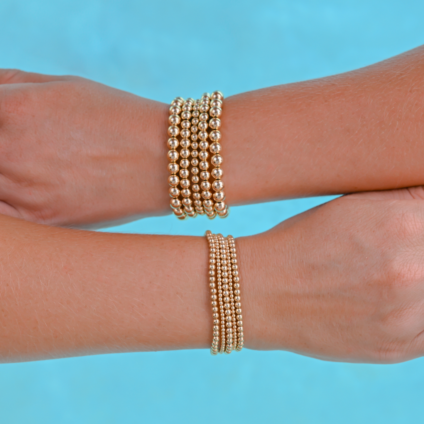 Gold-filled bracelets from Gold Club by Shannon Hudson displayed on a pool background—jewelry that is tarnish resistant, waterproof and sweat proof.