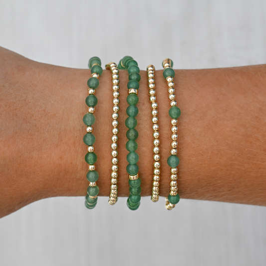 Layered Green Agate bracelets stacked on wrist with activewear, showcasing movement-friendly, luxury jewelry from GOLD CLUB by Shannon Hudson.