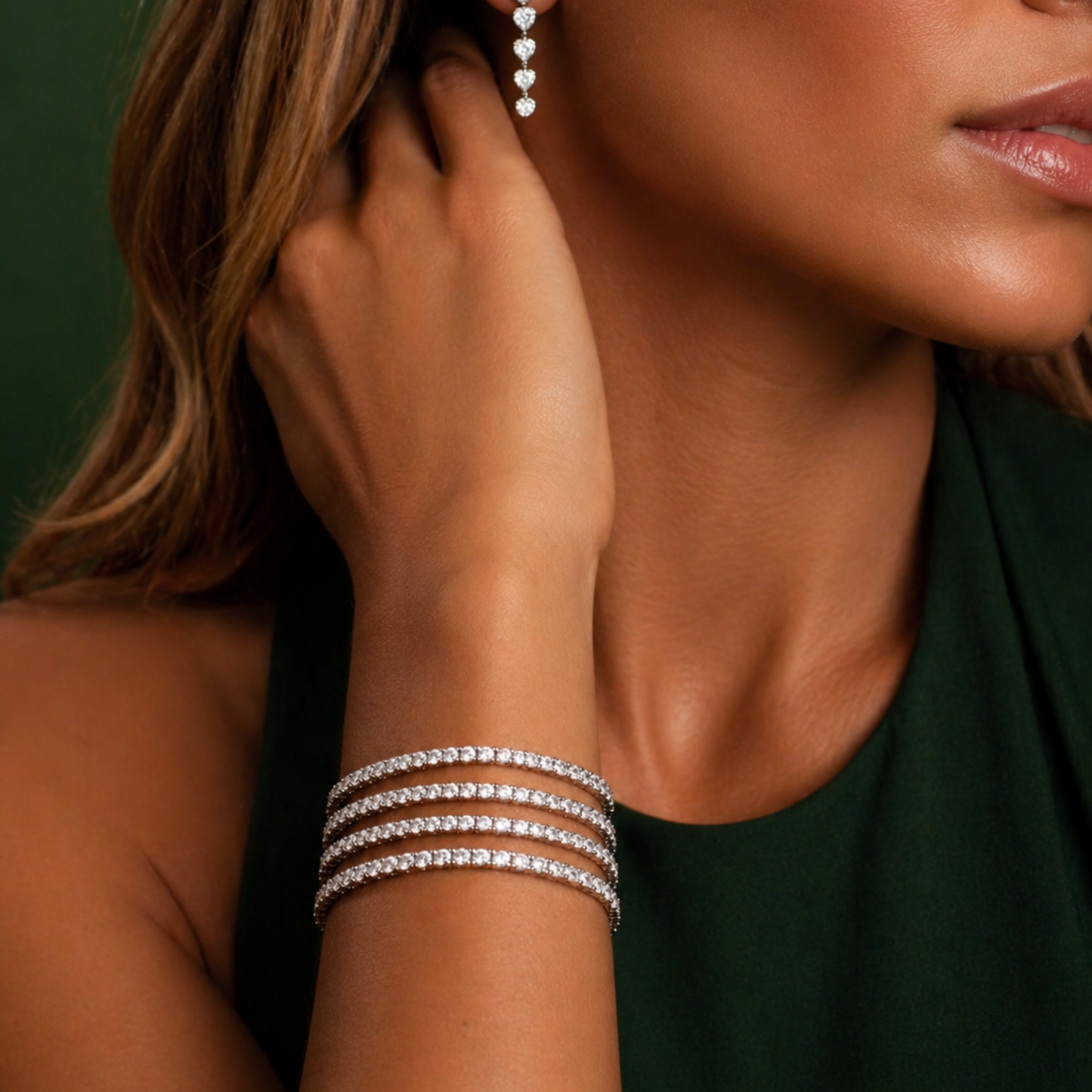 Close-up of a woman wearing a silver bracelet and earrings against a green background Lightweight Tennis Line Bracelet