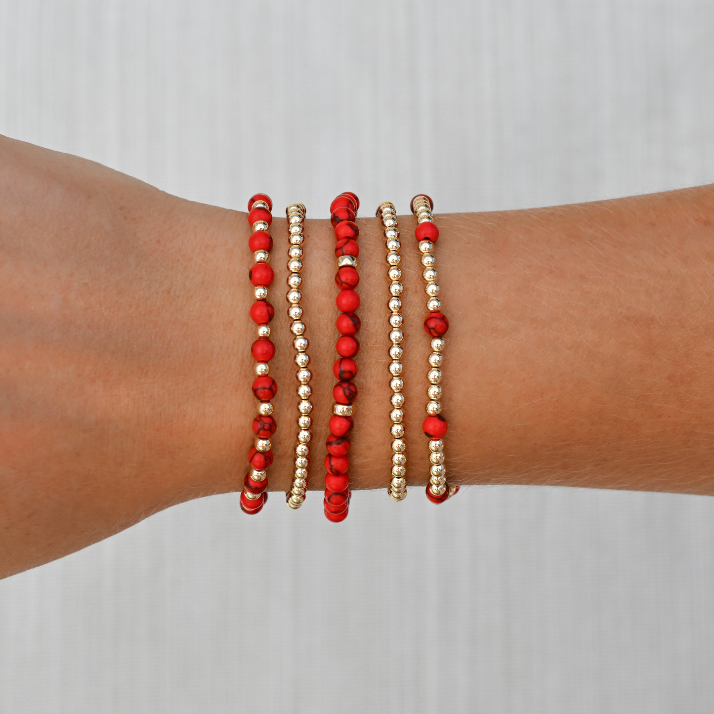 Detailed image of the Red Agate Signature Stack from GOLD CLUB, featuring layered gold-filled and gemstone bracelets styled together.