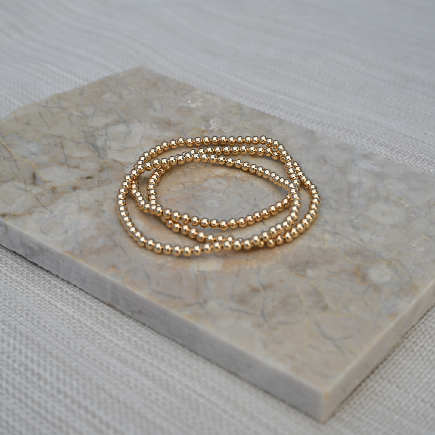 gold filled jewelry stack on marble slab