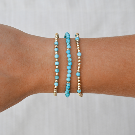Layered turquoise bracelets worn on wrist, styled for everyday movement with an empowering pop of color and polished finish.