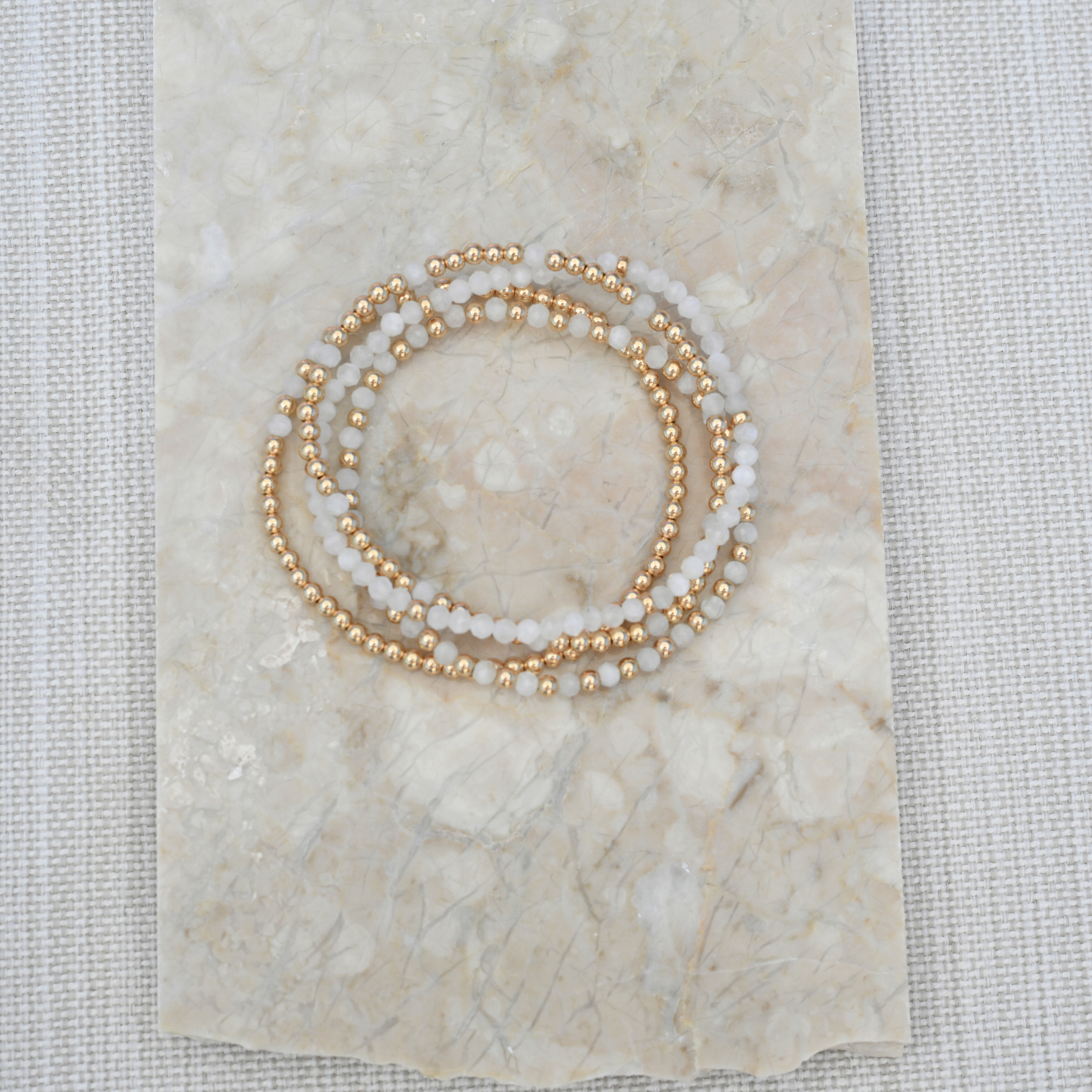 Natural White Moonstone and gold filled bracelet Stack catching the light in outdoor setting