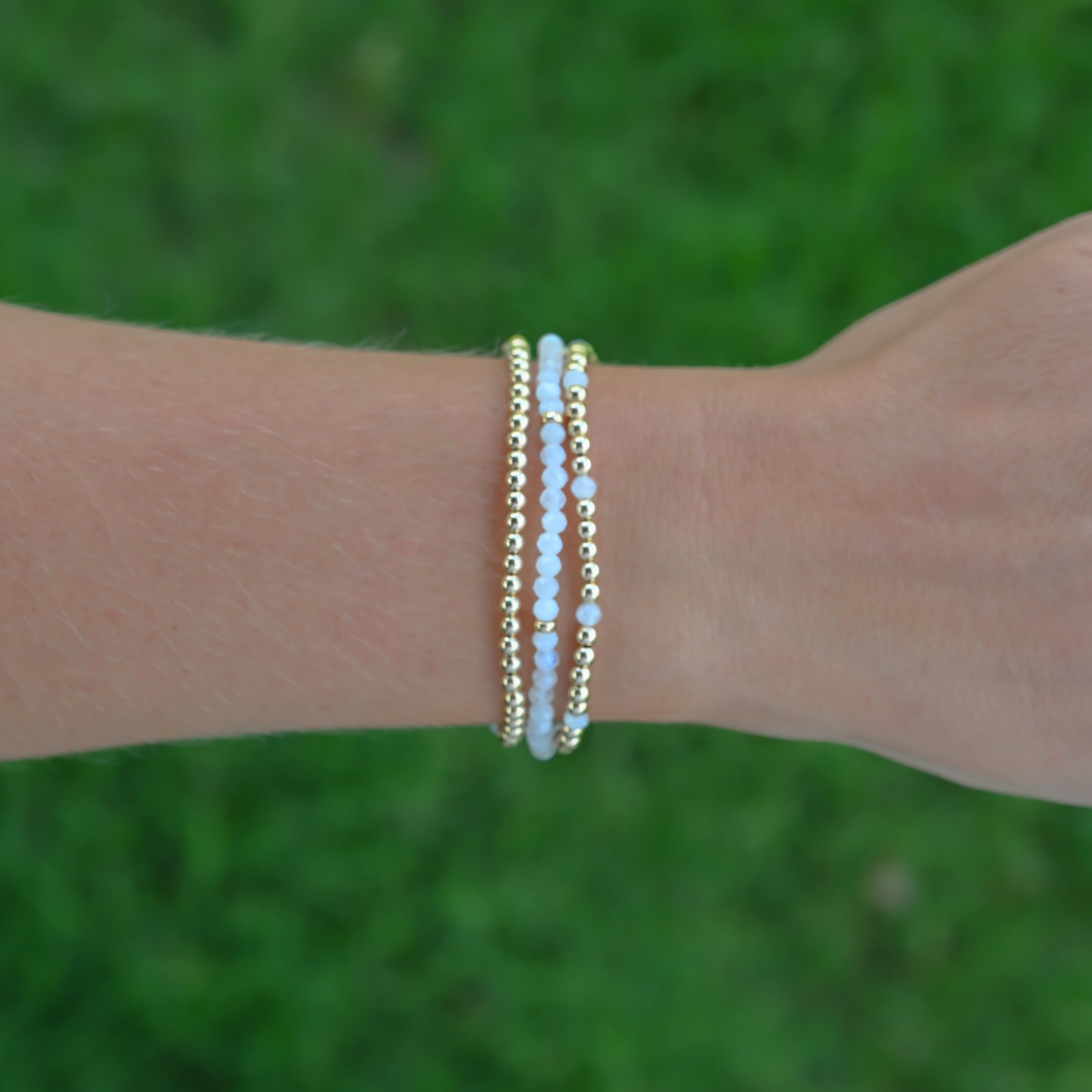 Gold Club by Shannon Hudson gemstone bracelet worn over an outdoor turf