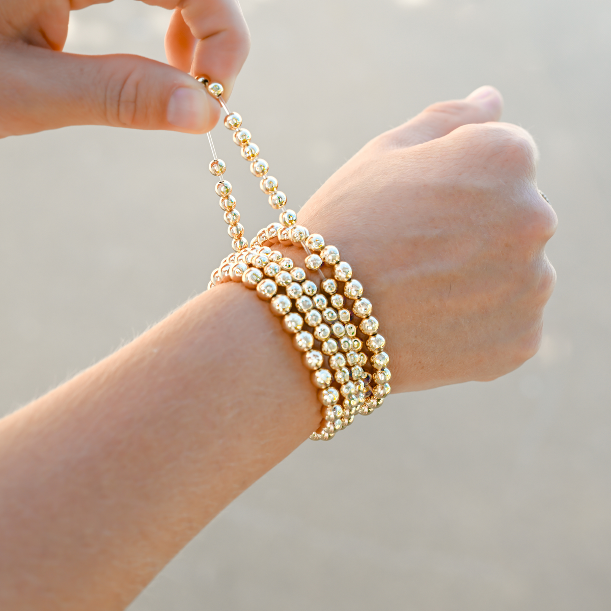 Close-up of Gold Club’s signature LustraFlex™ elastic bracelet with 5mm gold-filled beads.