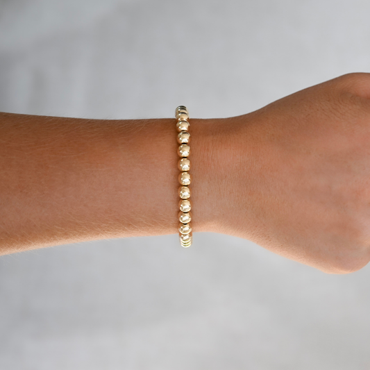 Minimalist 6mm gold-filled bracelet with flexible LustraFlex™ cord, part of the Gold Club collection.