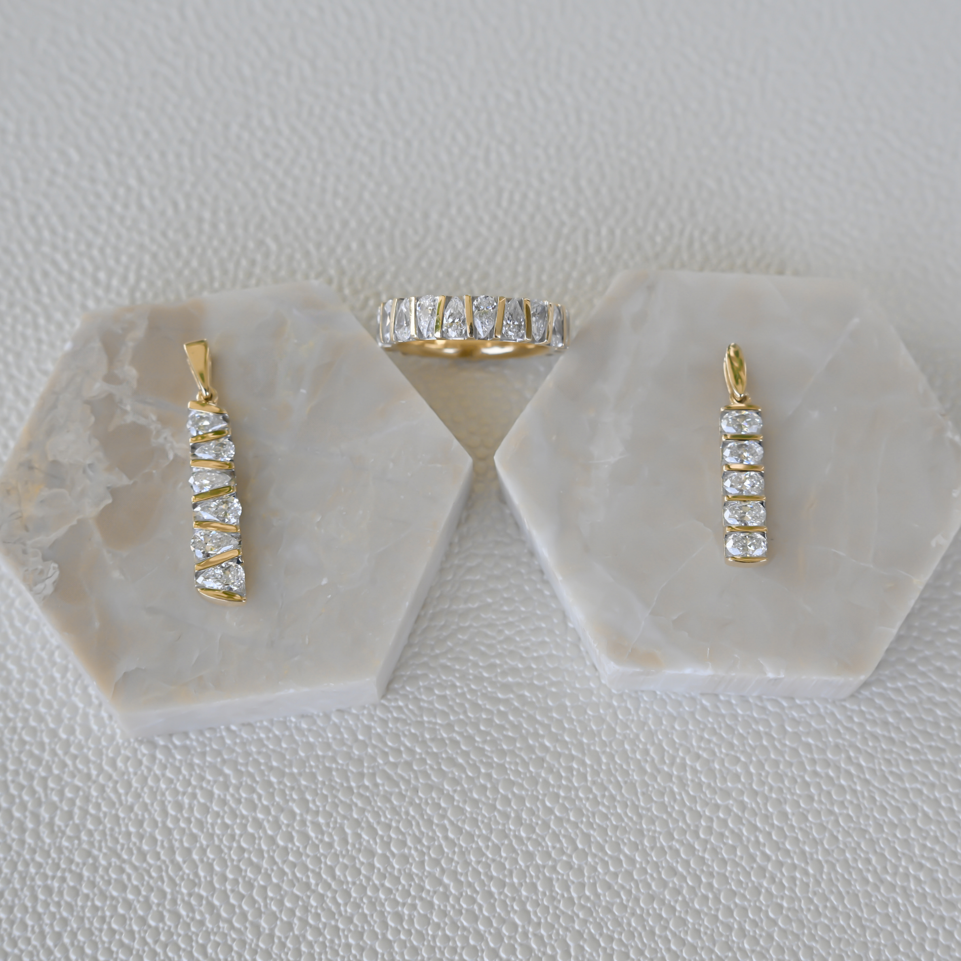 Display of Gold Club by Shannon Hudson fine jewelry featuring two lab-grown diamond bar pendants and a 14k gold diamond ring