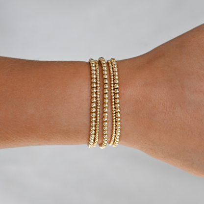 active lifestyle jewelry, gold filled bracelet stack on a wrist against a neutral background