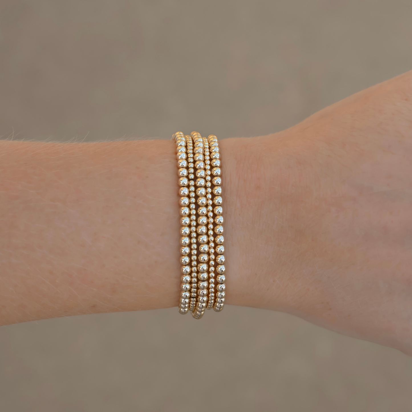 Gold-filled bracelet stack from Gold Club by Shannon Hudson displayed on a neutral background—jewelry designed for active lifestyles.