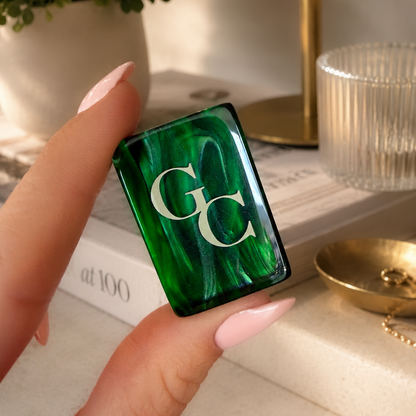 Close-up of Gold Club Mahjong tile featuring elegant green artwork beneath clear acrylic