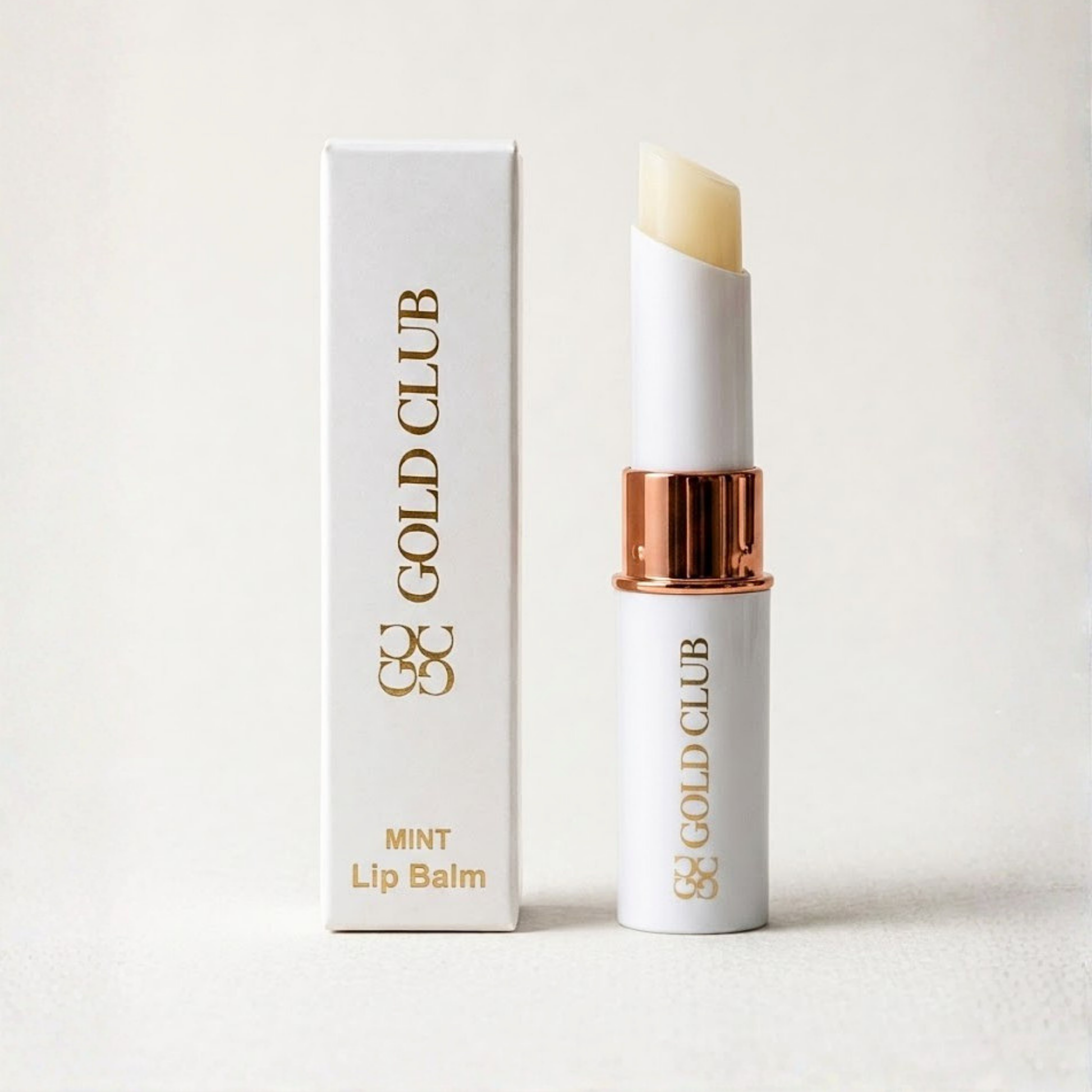 Gold Club lip balm with packaging on a light background