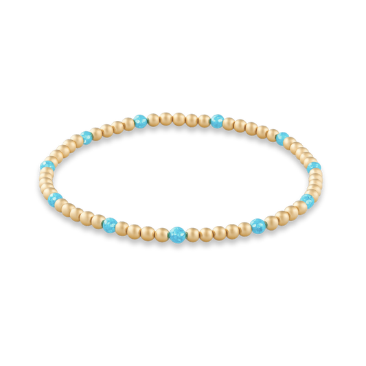Beaded bracelet with gold and turquoise beads on a white background