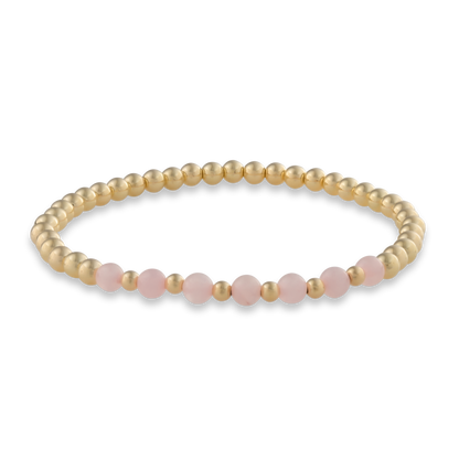 Minimal arc-style bracelet with smooth pink quartz beads framed in polished gold. Elegant, calming, and made for everyday wear.