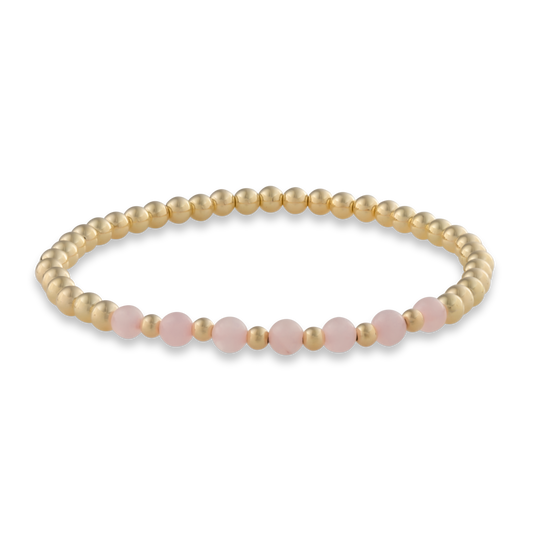 Minimal arc-style bracelet with smooth pink quartz beads framed in polished gold. Elegant, calming, and made for everyday wear.
