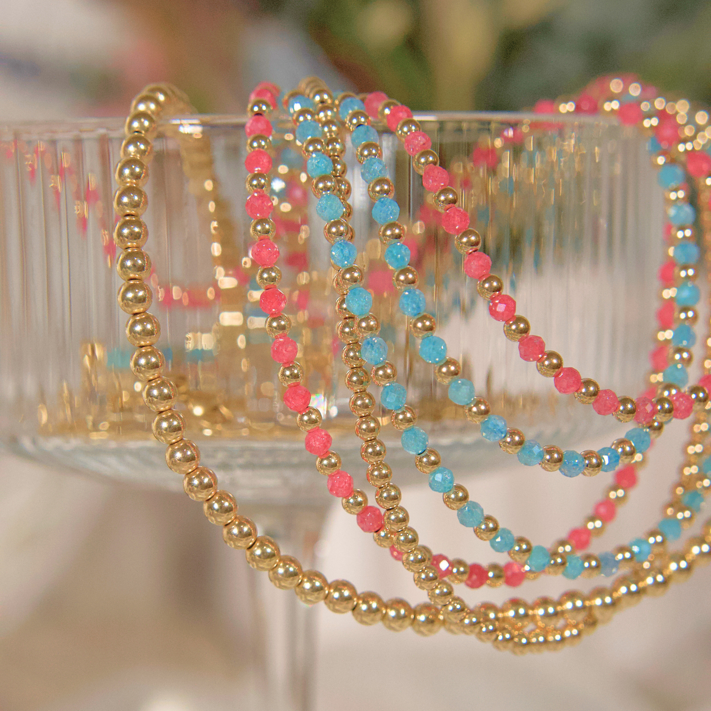 Pink Zircon, Light Blue (Aqua) Zircon and Gold Necklaces in a martini glass