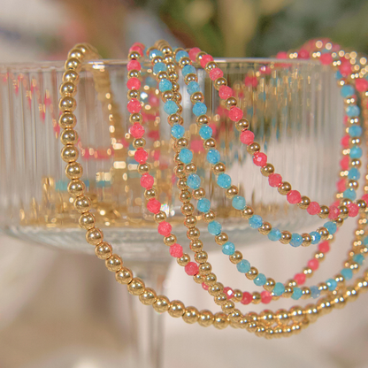 Pink Zircon, Light Blue (Aqua) Zircon and Gold Necklaces in a martini glass