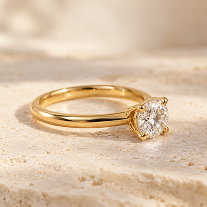 Yellow gold solitaire diamond ring on limestone, illustrating Gold Club jewelry repair services.