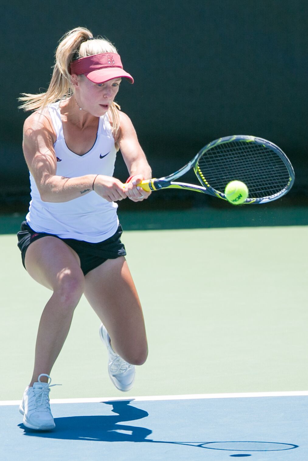 Tennis player in action on a court hitting a backhand.