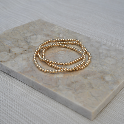 gold filled jewelry stack on marble slab