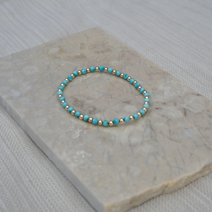 Close-up photo of the Turquoise Balanced bracelet placed on a stone tile, emphasizing color contrast and elevated materials.