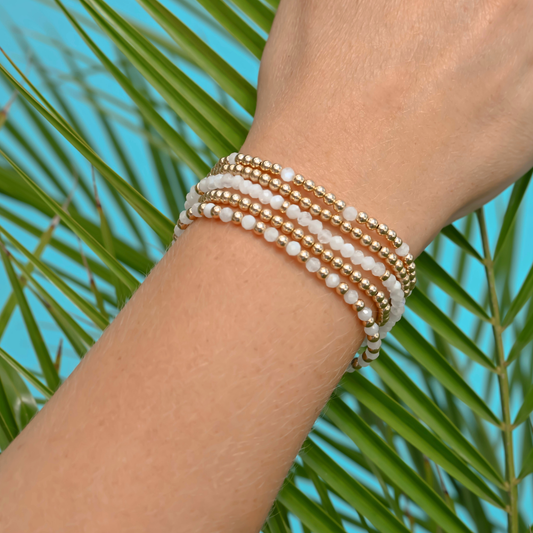 Woman wearing Gold Club white moonstone and gold bracelet stack for everyday luxury