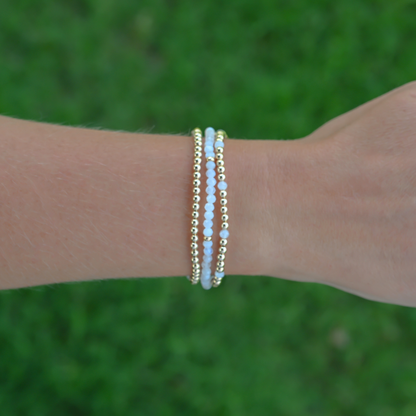 Gold Club by Shannon Hudson gemstone bracelet worn over an outdoor turf